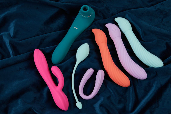Farverige vibratorer i silikone på mørkeblåt fløjlsstof
