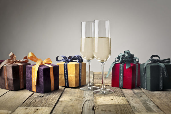Indpakkede gaver og champagneglas på et træbord